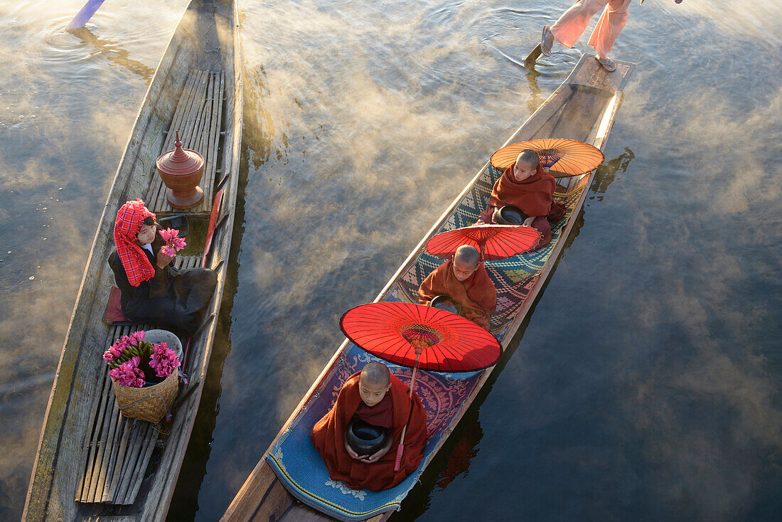 Asian gondoliers rowing canoes on river