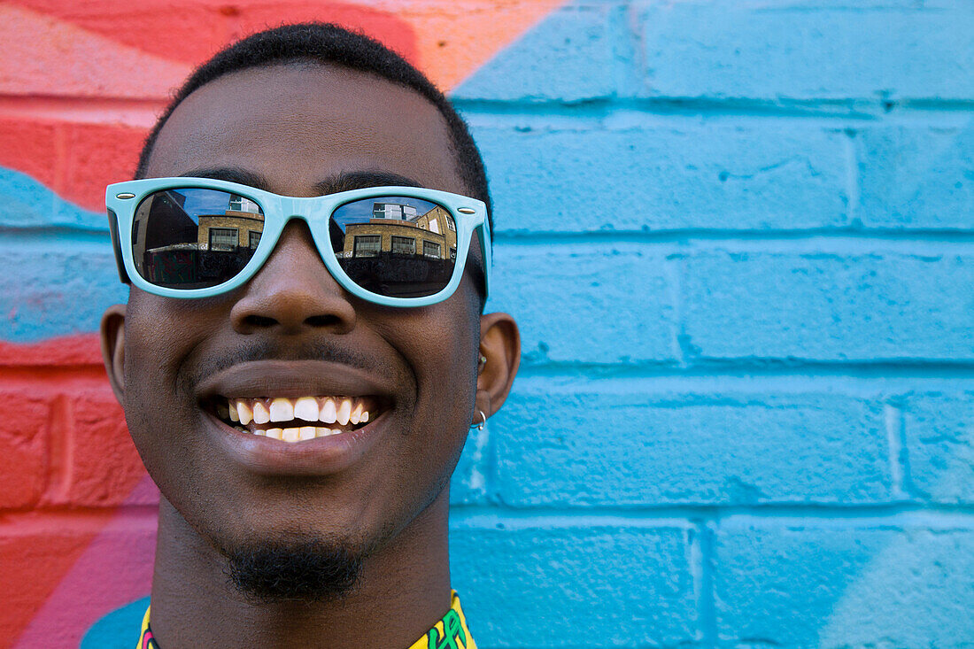 Close up of Black man wearing colorful sunglasses