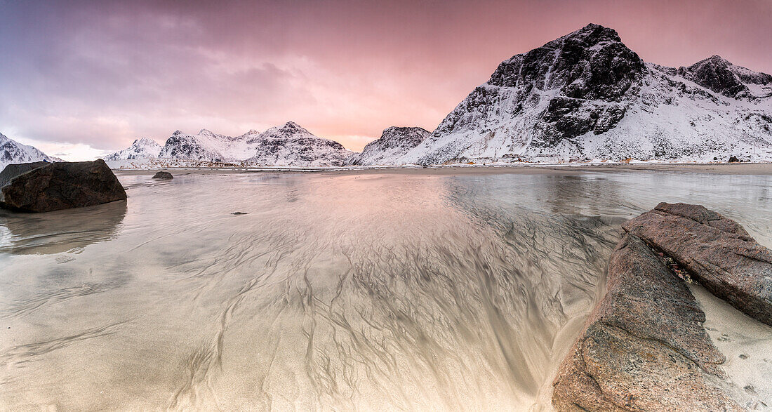 Sunset on the surreal Skagsanden beach surrounded by snow covered mountains, Flakstad, Lofoten Islands, Arctic, Norway, Scandinavia, Europe