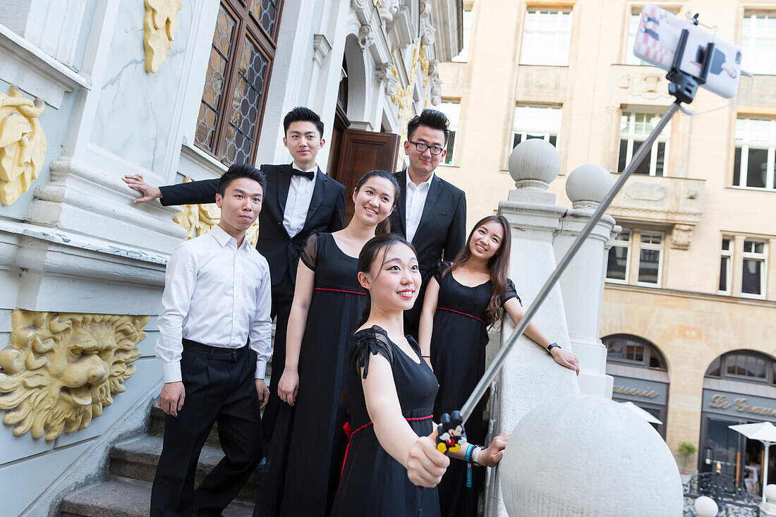 Junge Chinesen fotografieren sich selbst, Selfie, auf Treppe der Alten Börse, festlich gekleidet, chinesischer Chor beim Bachfest Leipzig 2015, Bachakademie, Leipzig, Sachsen, Deutschland