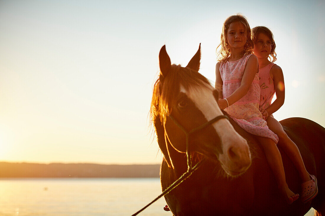 Two girls riding a quarter horse near Lake Starnberg, Upper Bavaria, Bavaria, Germany