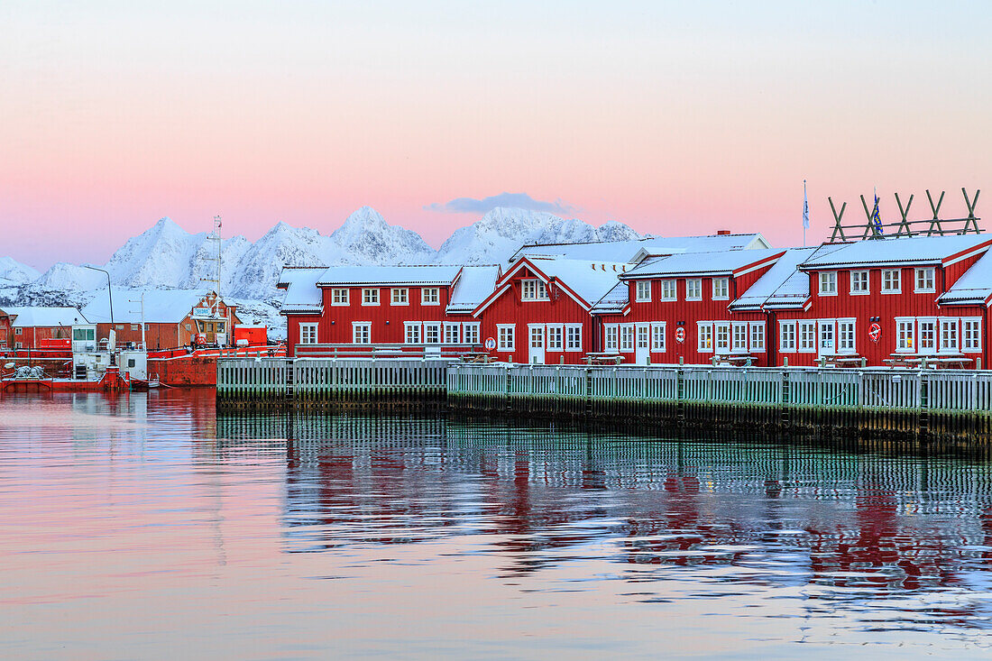 Pink sunset over the typical red houses reflected in the sea, Svolvaer, Lofoten Islands, Norway, Arctic, Scandinavia, Europe