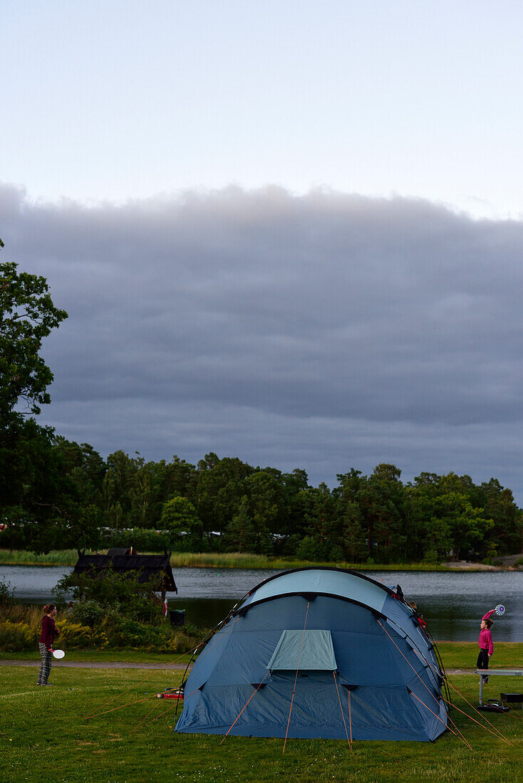 Zwei Mädchen spielen draußen Federball am Zelt, Campingplatz, Västervik, Smaland, Schweden