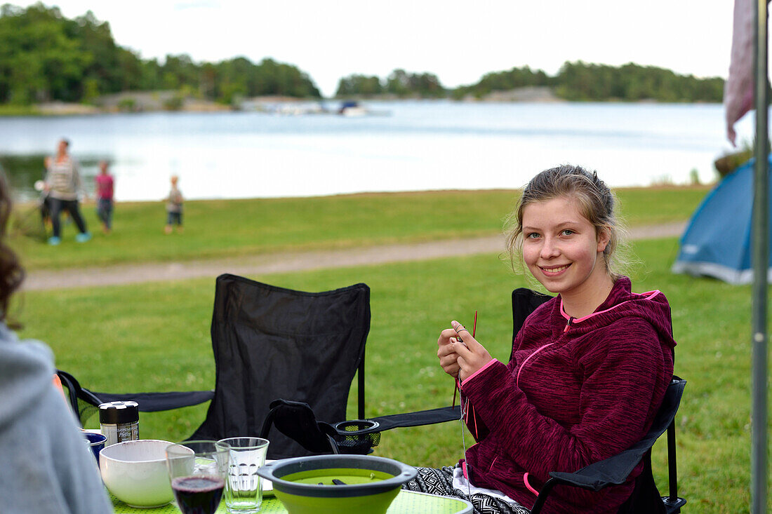 Girl knitting outside, camping ground, Vaestervik, Smaland, Sweden