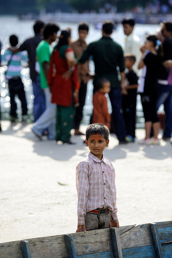 Boy standing at a boat in Pokhara, Nepal, Asia