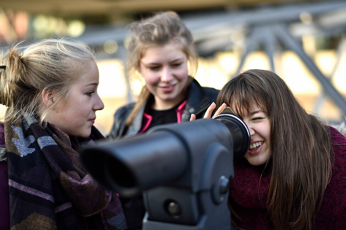 2 girls looking through a telescope in Hafencity, Hamburg, Germany, Europe