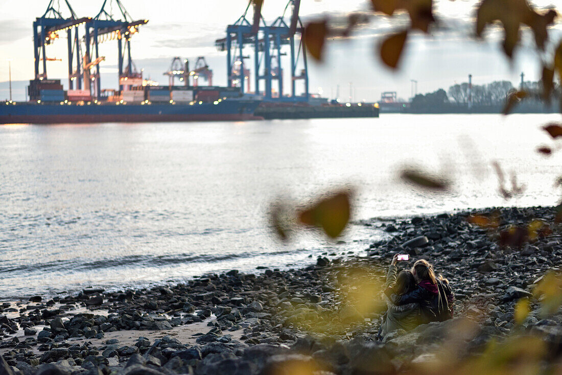 3 Mädchen machen Selfie am Elbstrand, Övelgönne, Hamburg, Deutschland, Europa