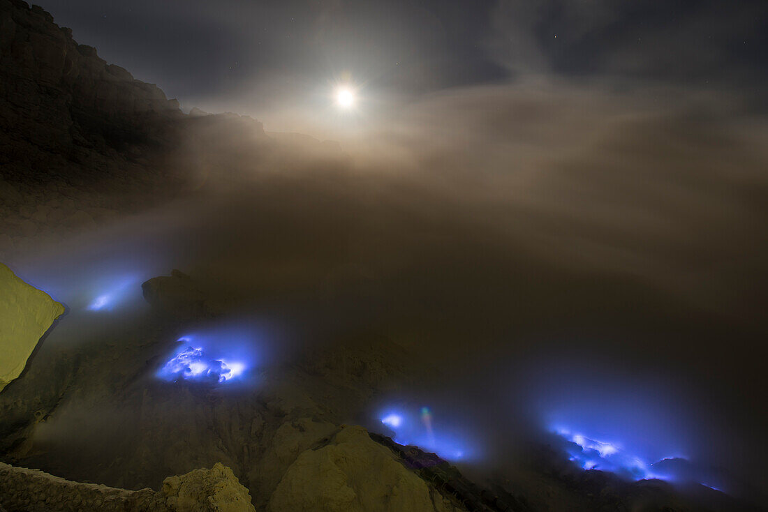 Brennender Schwefel mit blauer Flamme des Vulkan Ijen bei Nacht mit Vollmond und Sternen, Ost-Java, Vulkan Ijen, Indonesien