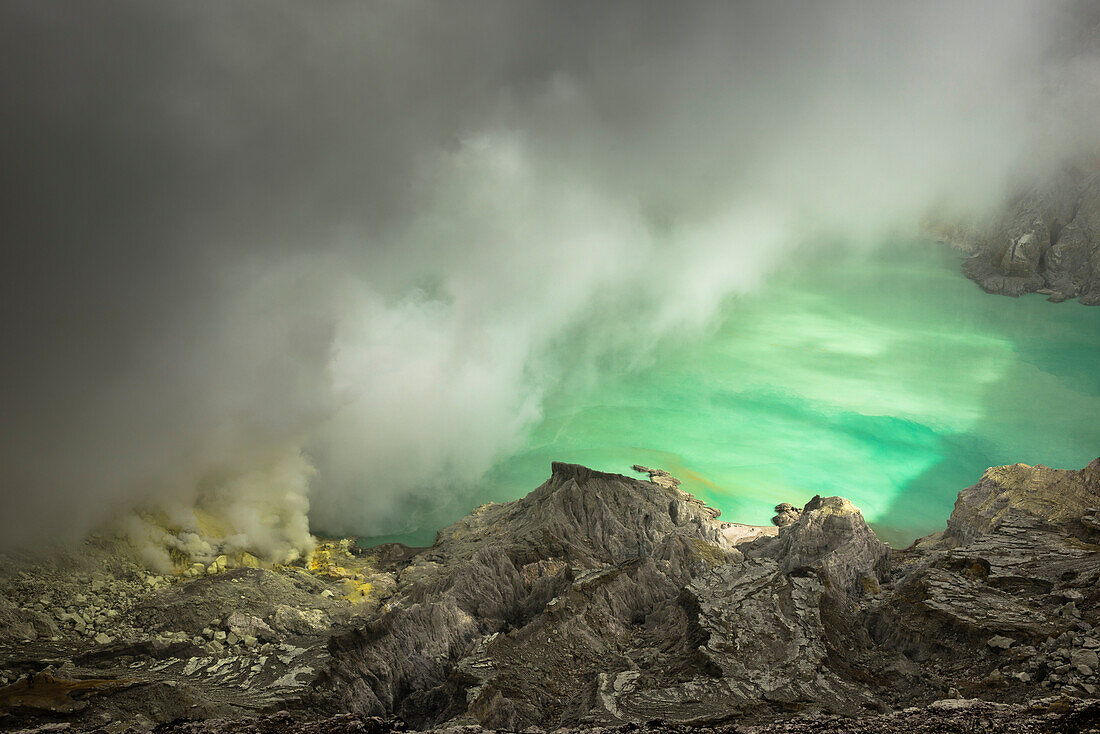 Türkiser Säuresee mit Schwefelgasen des aktiven Vulkan Ijen am Tage. Sonne leuchtet auf See und Umgebung, Ost-Java, Vulkan Ijen, Indonesien