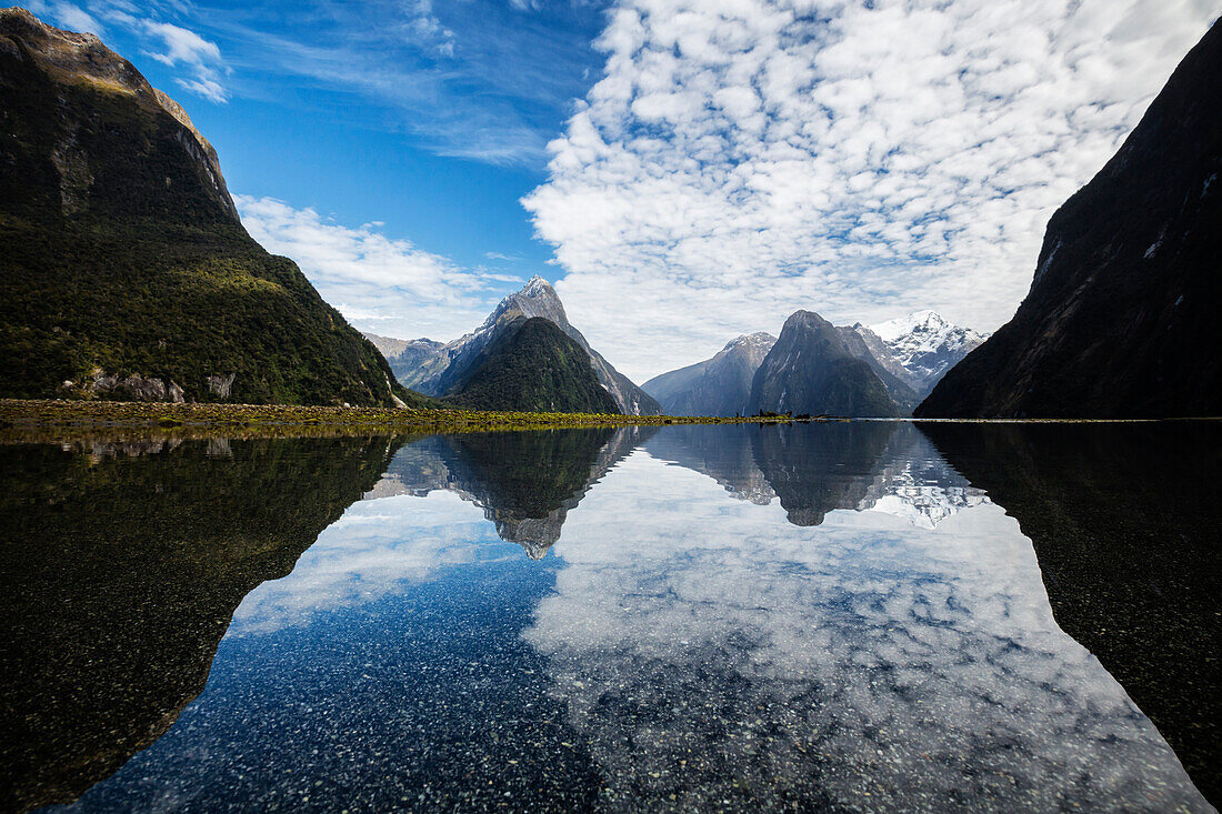 Mountains reflecting in remote lake, Milford Sound, Fiordland, New Zealand
