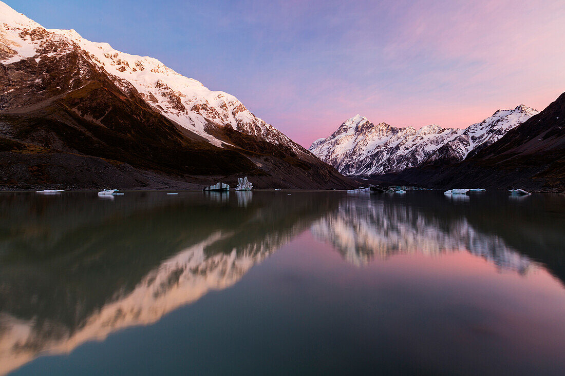 Snowcapped mountains reflecting in still lake, Mount Cook Village, Mckenzie Country, New Zealand