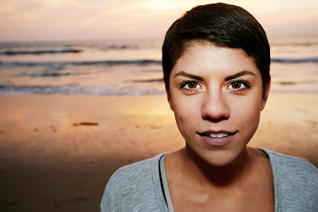 Serious Hispanic woman standing on beach