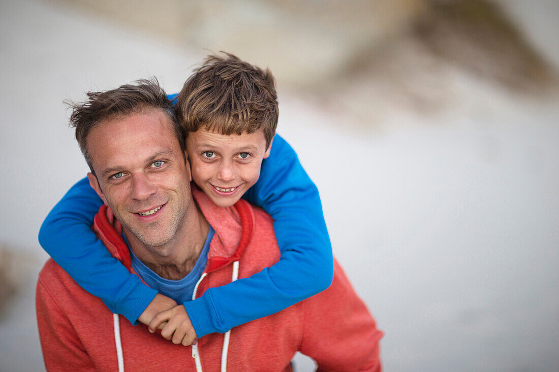 Caucasian father carrying son piggyback outdoors