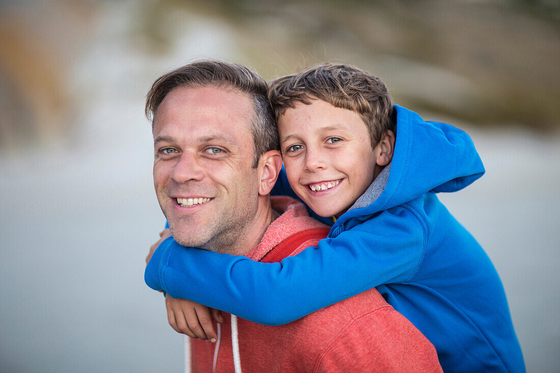 Caucasian father carrying son piggyback outdoors