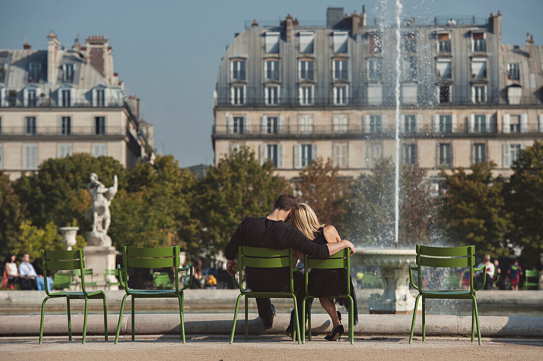 Caucasian couple admiring fountain in urban park, Paris, Ile-de-France, France