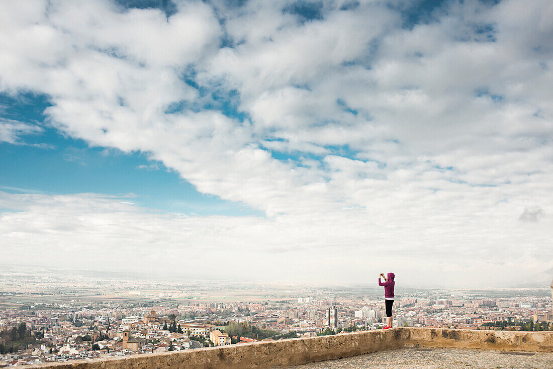 Caucasian woman photographing scenic view of cityscape, Granada, Spain