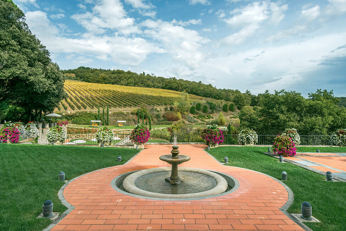 Fountain and walkway in landscaped grounds over rural fields, Radda in Chianti, Siena, Italy