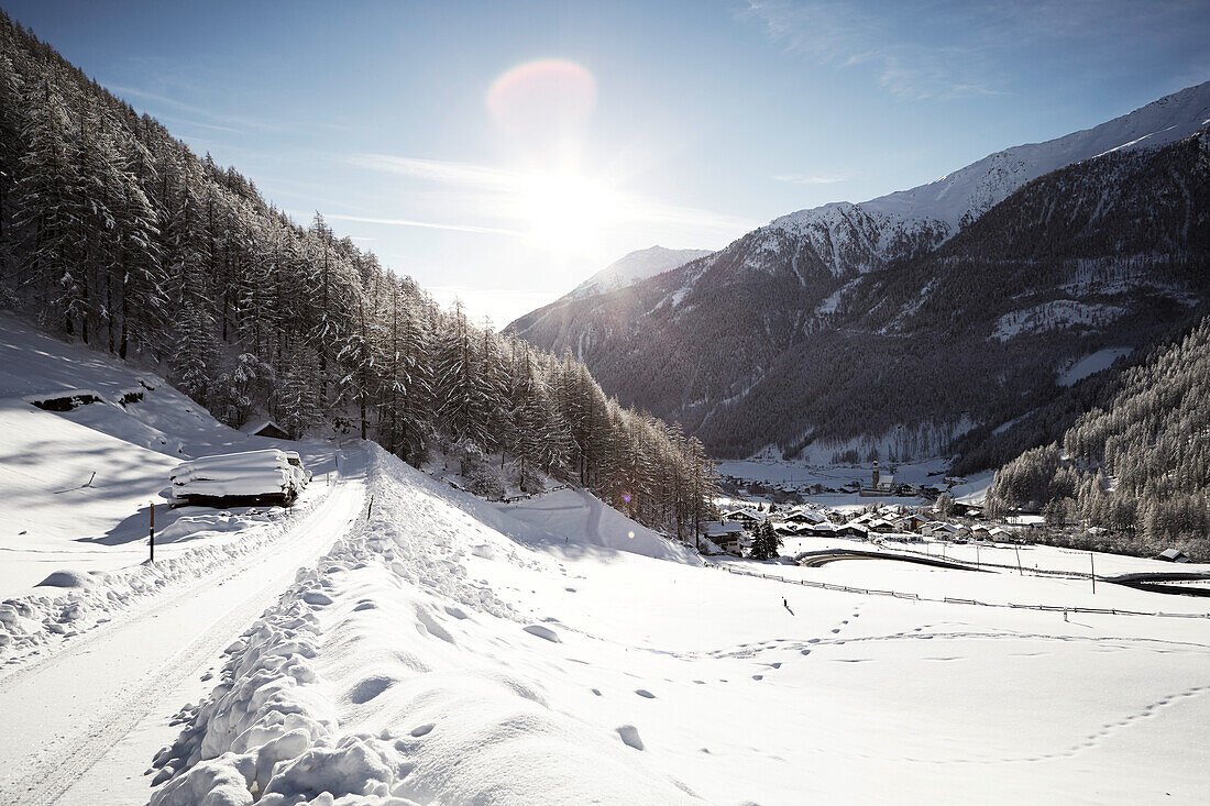 verschneite Strasse in Winterlandschaft und Dorf, Unser Frau, Schnalstal, Südtirol, Italien