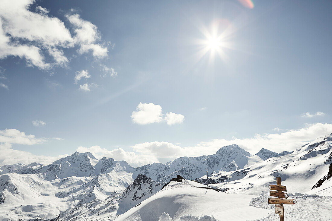 Wegweiser und sonnige, verschneite Berge und Skigebiet, Schnalstaler Gletscher, Südtirol, Italien