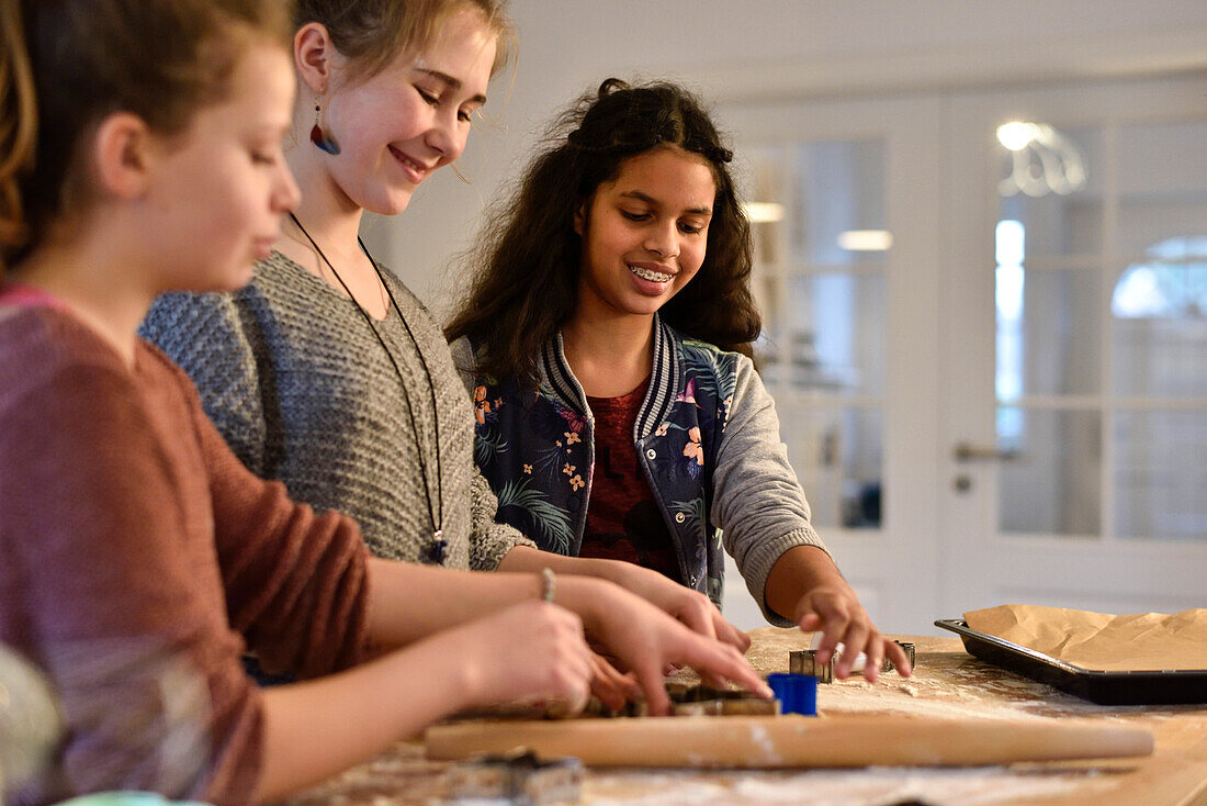 11 years old girls baking christmas cookies, cutting out dough, Hamburg, Germany