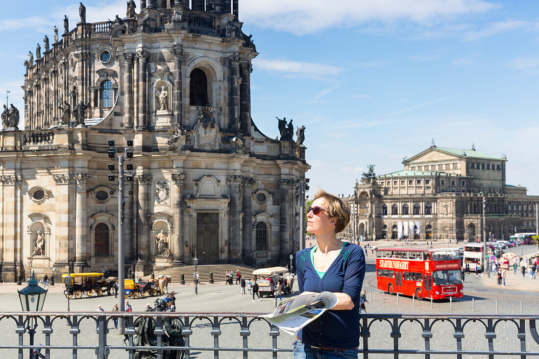 Female tourist with city map, guide book, view from Bruehl's Terrace towards Dresden cathedral, Catholic Court Church and Semper Opera House, MR, Dresden, Saxony, Germany, Europe