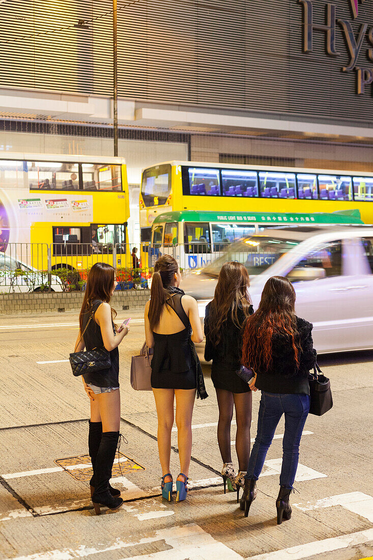 Four young Chinese women on the street, traffic, sexy, shopping area Causeway Bay, handbags, evening, Hong Kong, China, Asia