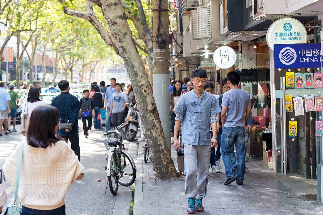 Tianzifang, Junger Mann, Platanen über Straße, China Mobile Geschäft, Straßenszene, Bummelgegend, Einkaufsstraße, Schanghai, Shanghai, China, Asien