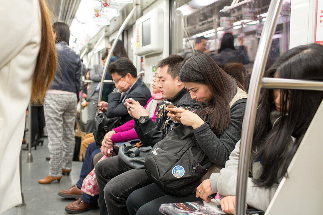 passengers, commuters look into their mobiles, smartphones telephones,sleeping, public transport, Shanghai, China, Asia