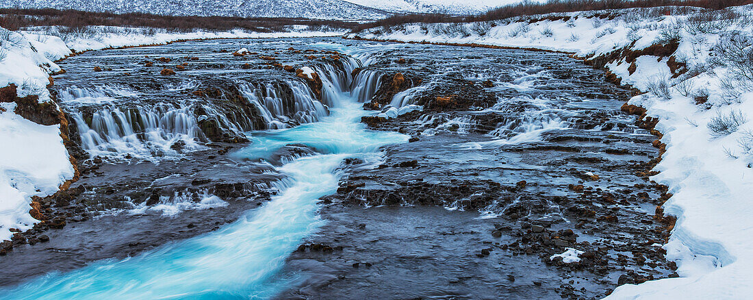 Turquoise water flowing over rocks into a river, Bruarfoss, Iceland