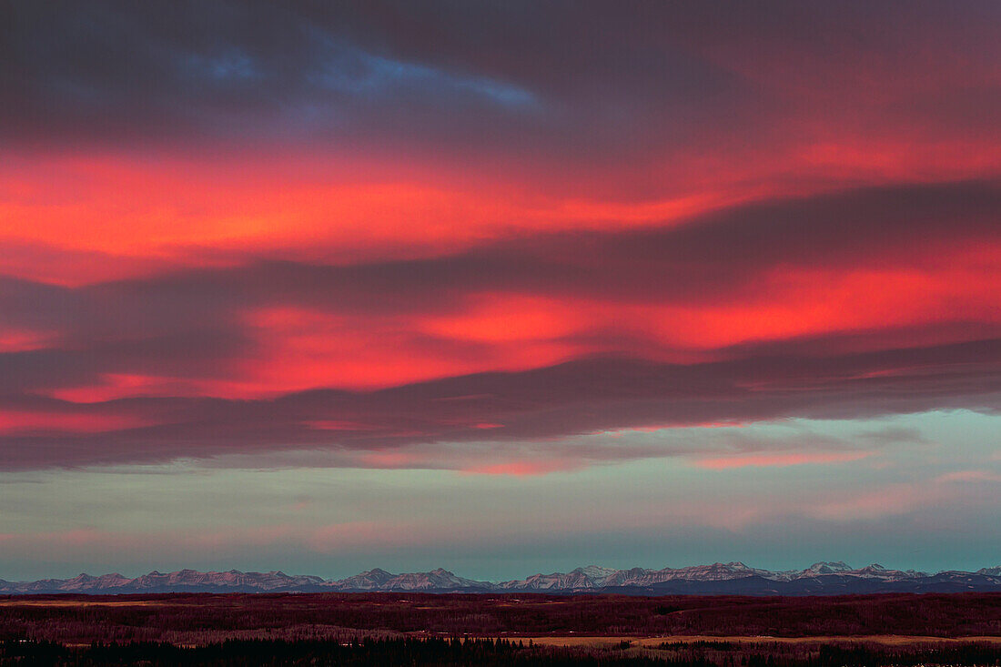 Dramatic colourful sky at sunrise with mountain range in the distance, Calgary, Alberta, Canada