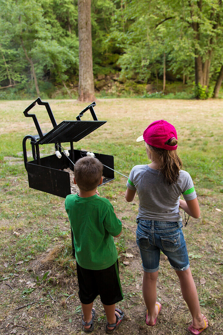 Two kids roasting marshmallows at Bixby State Preserve, near Edgewood, Iowa, United States of America