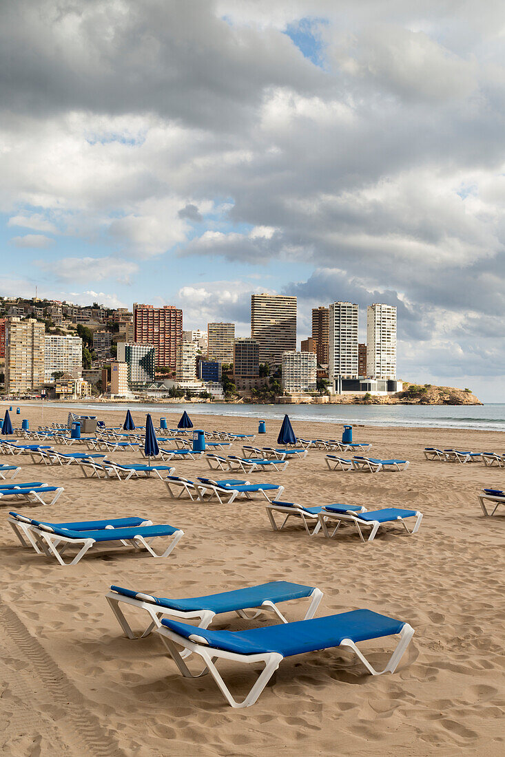 Blue lounge chairs on the beach along the mediterranean, Benidorm, Spain