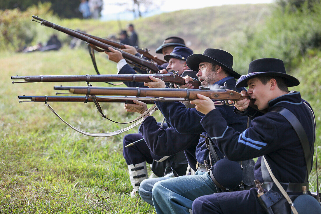 A line of American Civil War union re-enactors on the battlefield with guns in the firing position, United States of America