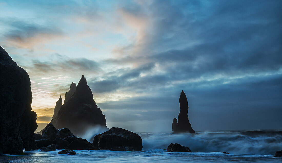 Large waves crash against the rocks and southern shoreline near Vik, Iceland