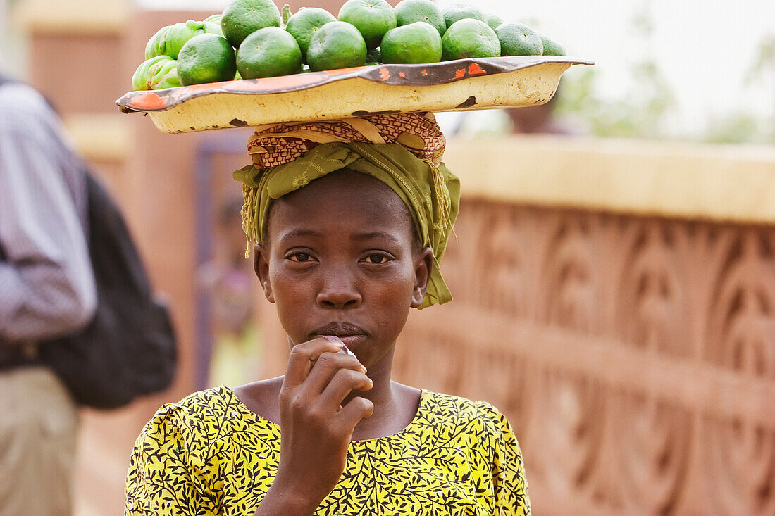 Girl carrying fruits on her head in Segou, Mali