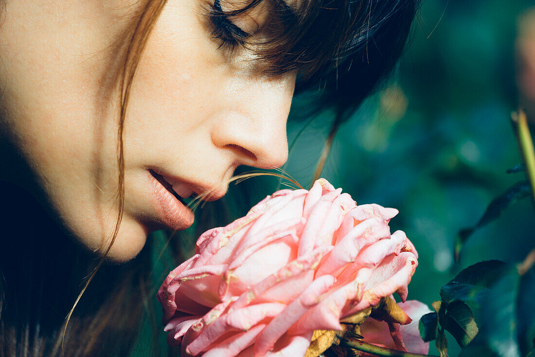 Young Adult Woman Smelling Pink Rose