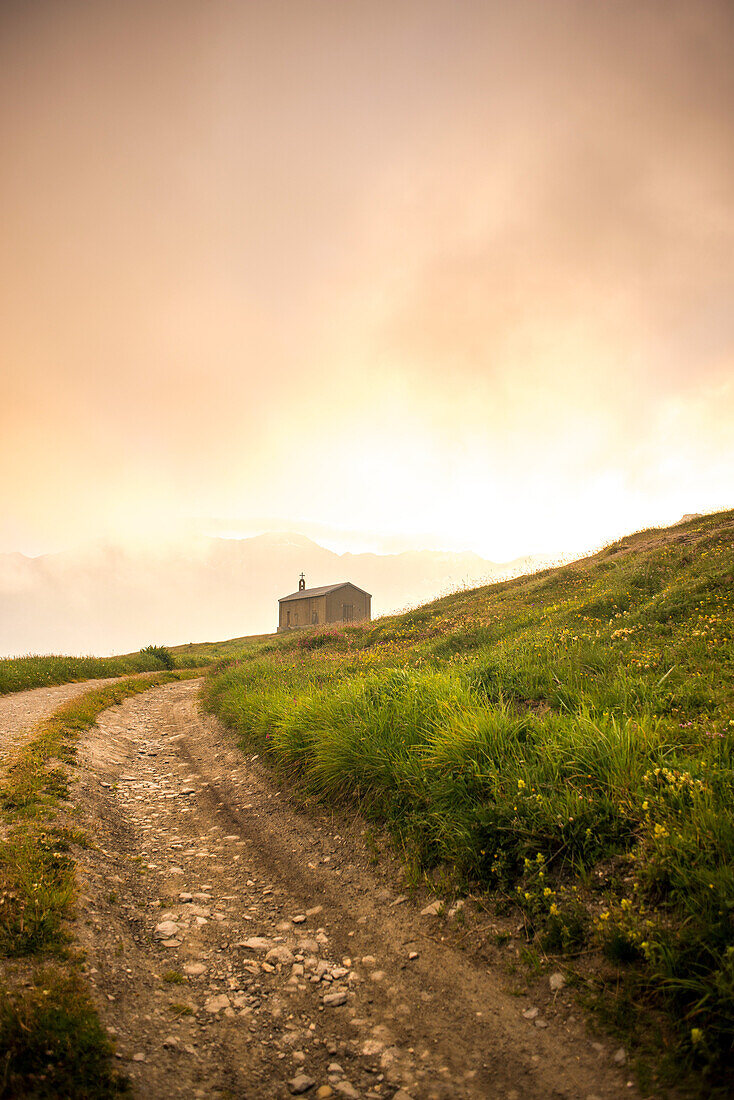 Rural Dirt Road Leading to Church at Sunrise