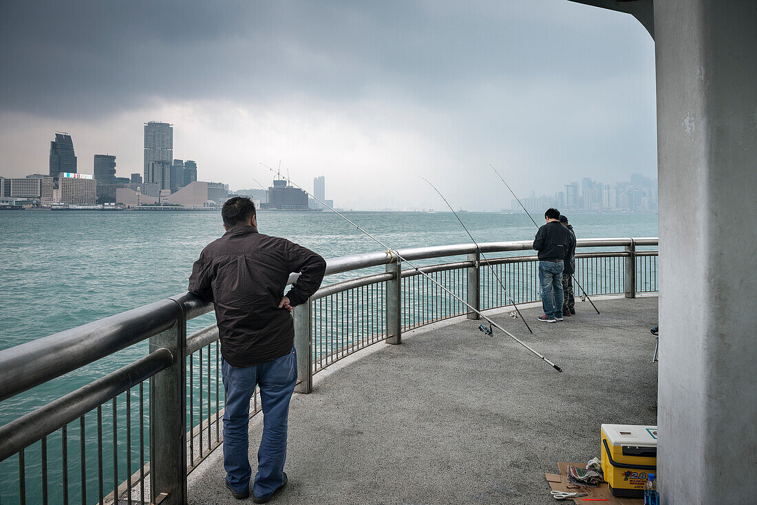 chinese residents fishing at Victoria Harbour with view towards Kowloon, Hongkong Island, China, Asia