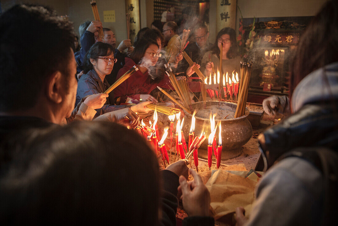 Gläubige im Man Mo Tempel zünden Räucherstäbchen an, Hongkong Island, China, Asien