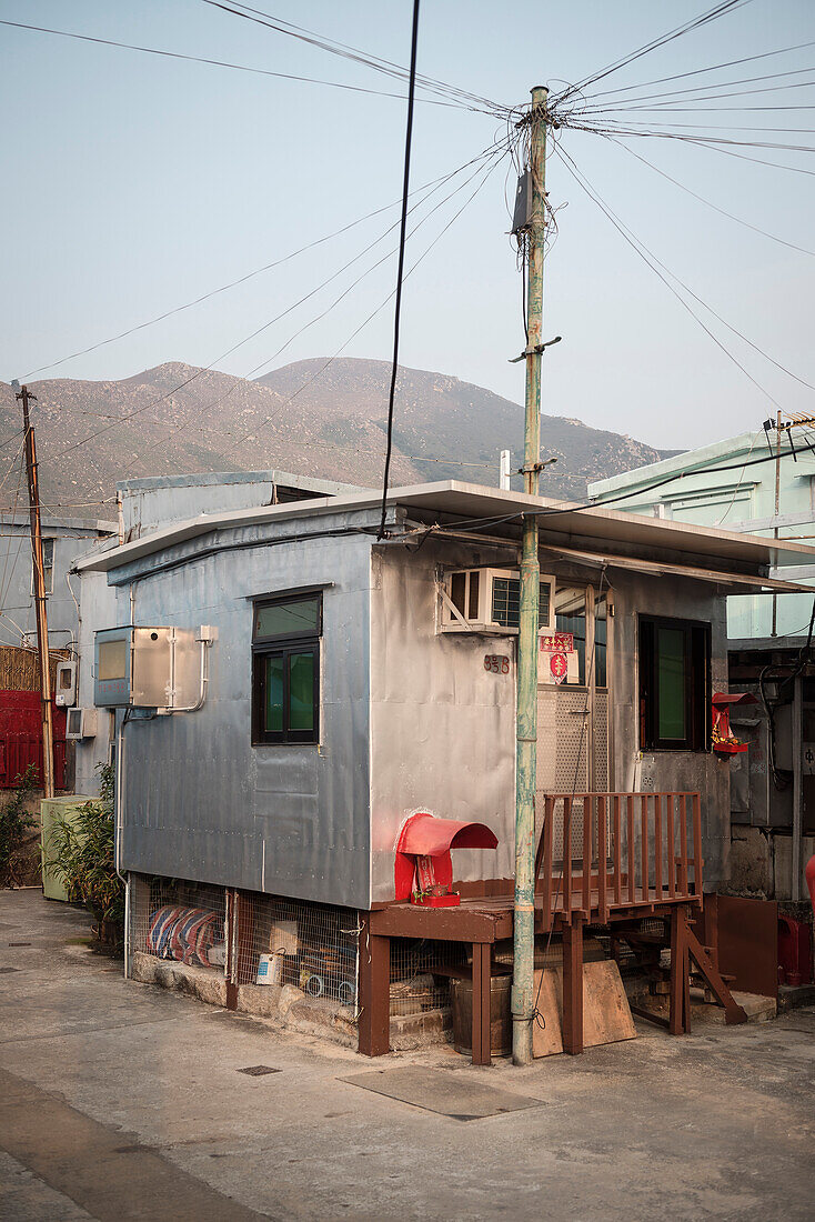 spärtliche Behausung und Strommast im Fischerdorf Tai O, Insel Lantau, Hongkong, China, Asien