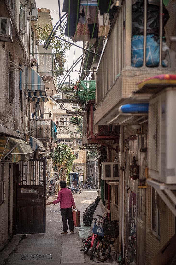 chinesische Frau verlässt ihr Haus in den engen Gassen auf Insel Cheng Chau, Hongkong, China, Asien