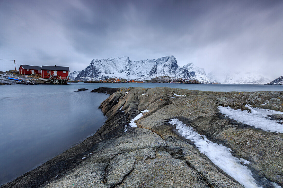 Typical landscape of Hamnoy with red houses of fishermen and the snowy mountains, Lofoten Islands, Northern Norway, Scandinavia, Arctic, Europe