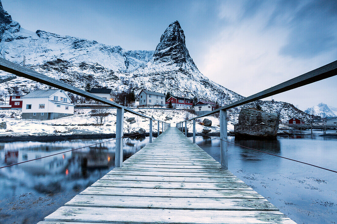 A bridge over the cold sea connects a typical fishing village. Reine, Lofoten Islands, Northern Norway, Scandinavia, Arctic, Europe