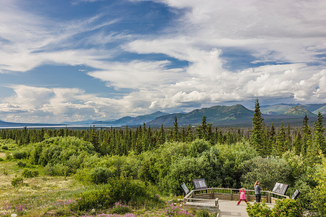 Mother and daughter view scenery from a platform along the Alaska Highway south of Kluane Lake, Yukon Territory, Canada, summer