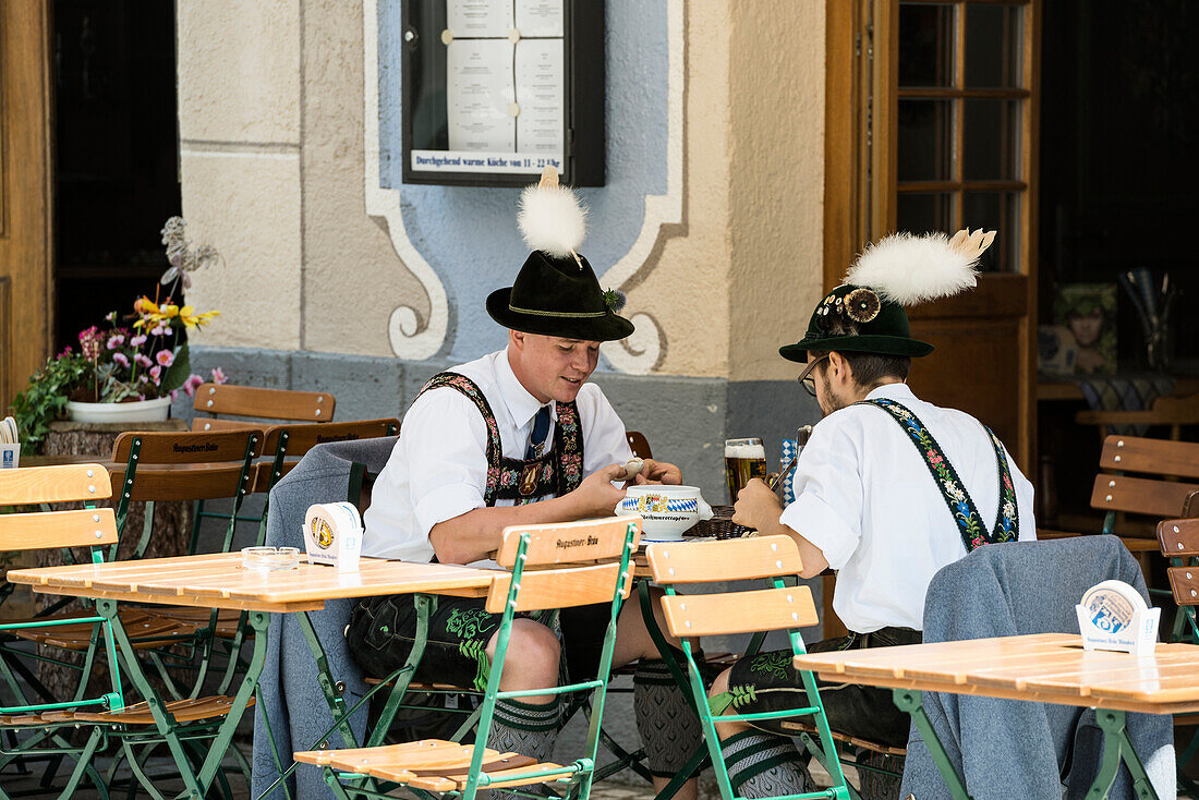 Men having a traditional weisswurst sausage, traditional prozession, Garmisch-Partenkirchen, Bavaria, Germany