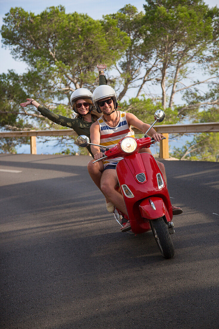Junges Paar fährt roten Vespa Motorroller auf Straße entlang der Halbinsel Cap de Formentor, Cap de Formentor, Palma, Mallorca, Balearen, Spanien