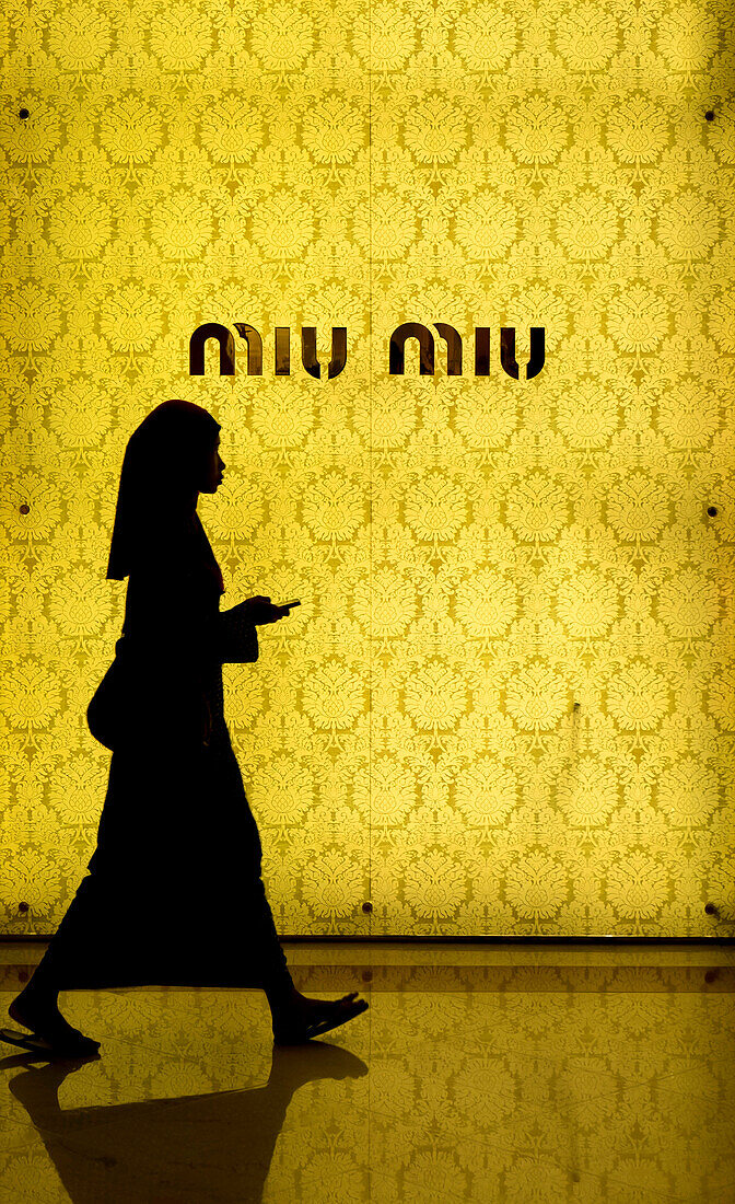 Muslim woman walking in front of the fashion store Miu Miu, Kuala Lumpur, Malaysia, Southeast Asia, Asia