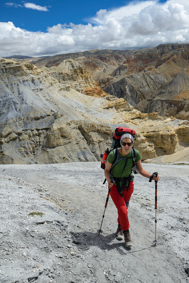 Young woman, hiker, trekker in the surreal landscape typical for Mustang in the high desert around the Kali Gandaki valley, the deepest valley in the world, Mustang, Nepal, Himalaya, Asia