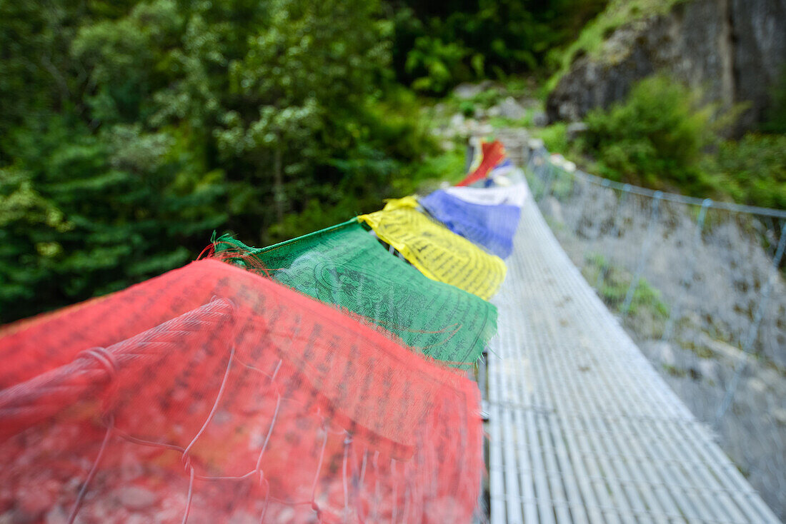 Gebetsfahnen an einer Haengebruecke auf dem Nar Phu Trek, Nepal, Himalaya, Asien