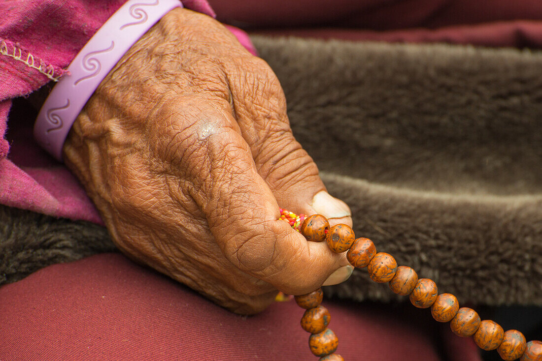 Buddhistischer Moench beten mit der Gebetskette Mala aus 108 Perlen die fuer die 108 Baende der gesammelten Lehre Buddas stehen, Nar, am Nar Phu Trek, Nepal, Himalaya, Asien